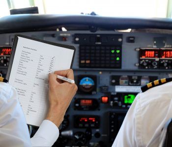 Two Pilots in aircraft with a checklist