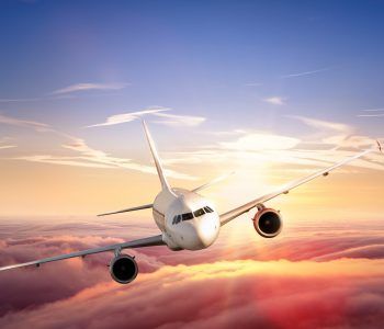 Commercial airplane jetliner flying above clouds in beautiful sunset light. Travel and business concept
